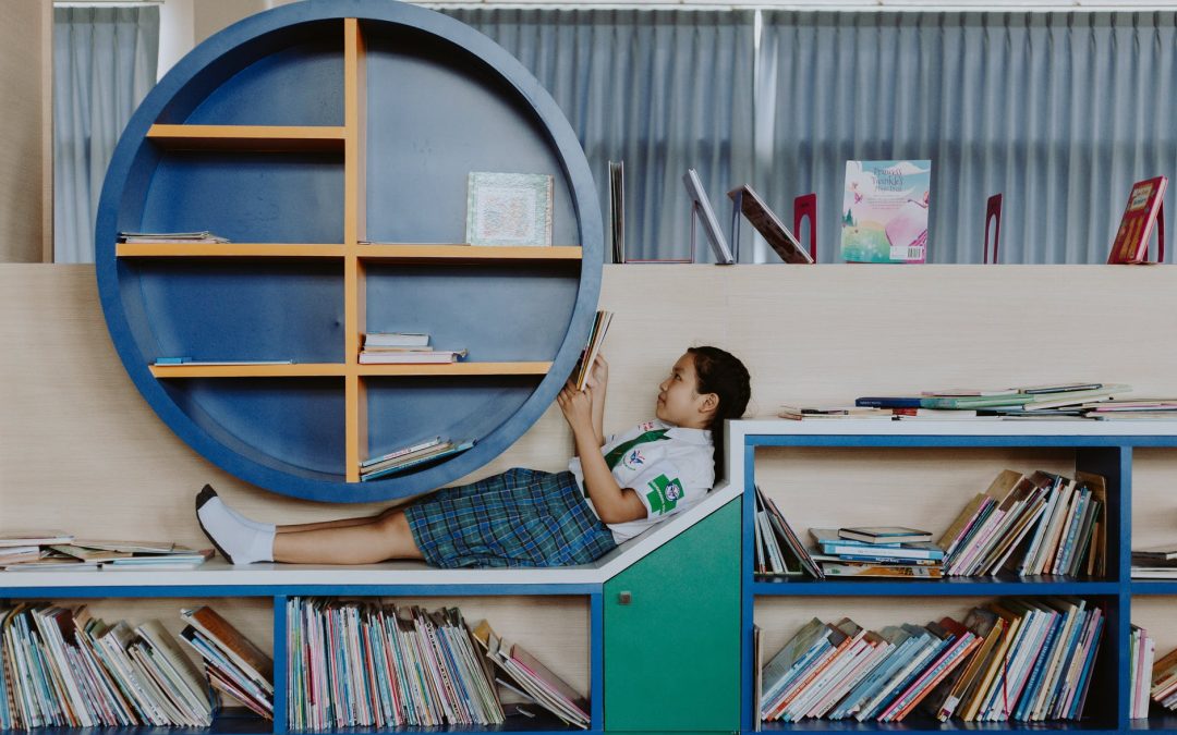 girl in school uniform lying on book shelf and reading